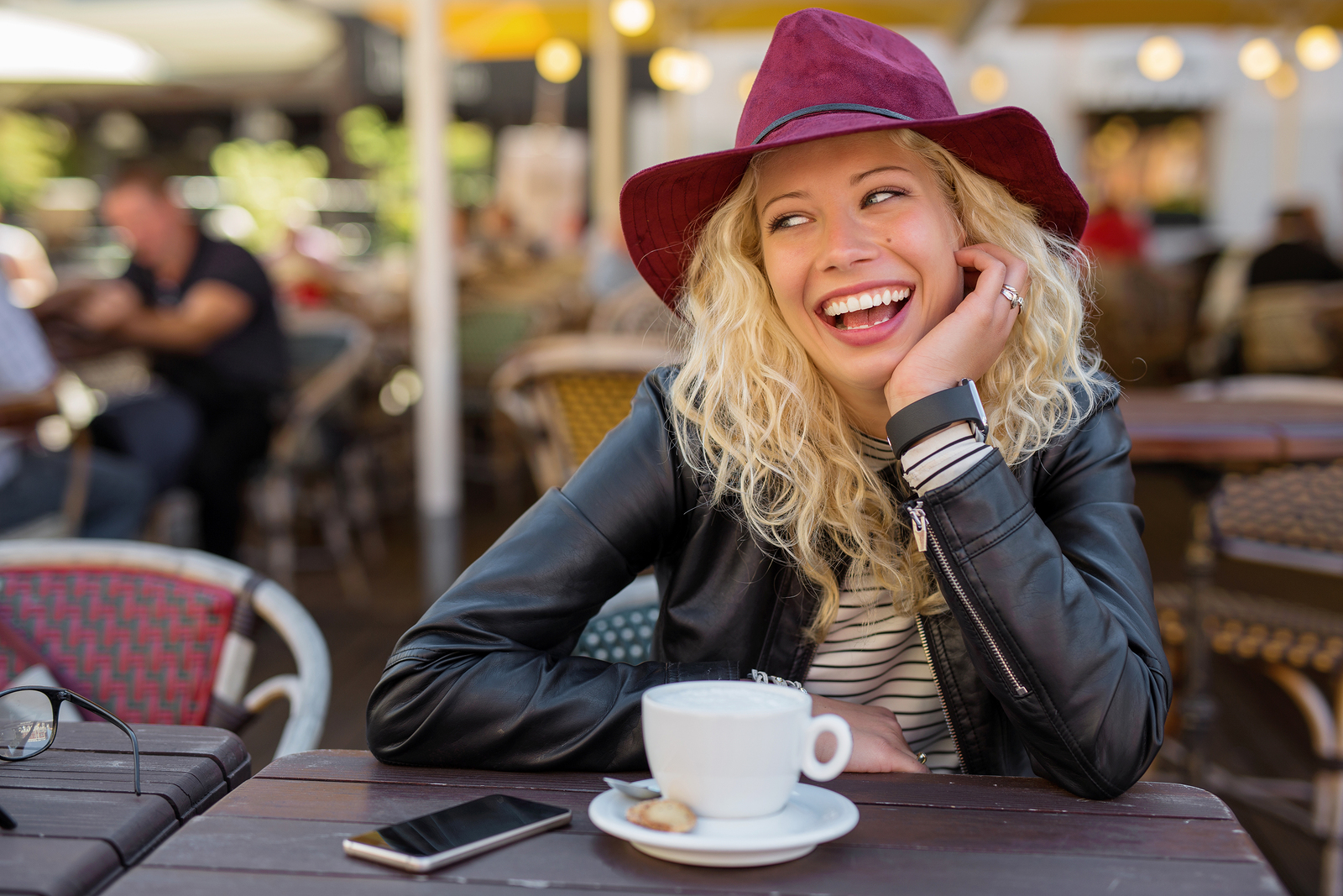 Beautiful woman with red hat laughing while on coffee break